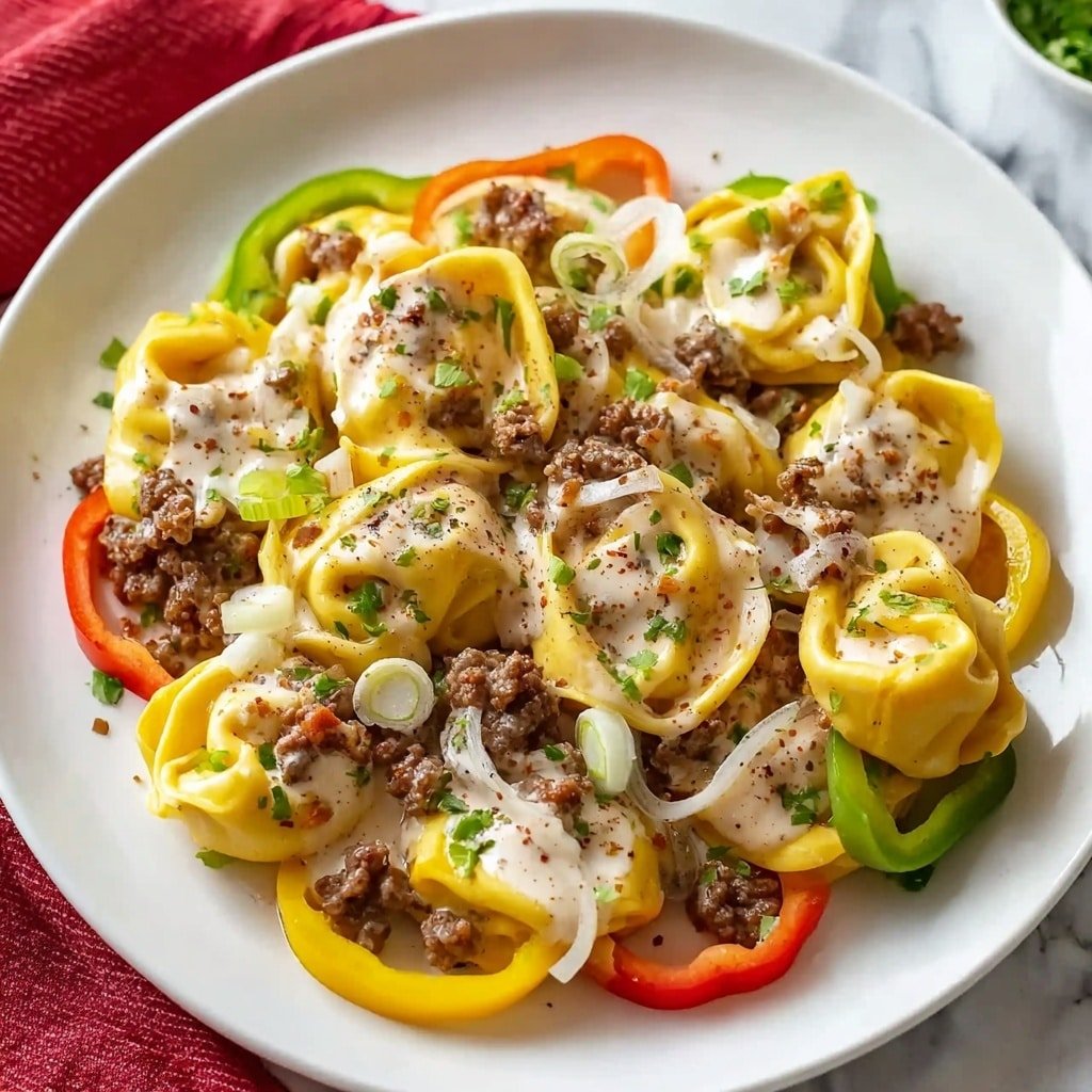 Cheesesteak Tortellini Recipe - Article Image 1 — Cheesesteak Tortellini, cheesesteak tortellini recipe, easy cheesesteak pasta, slow cooker cheesesteak dish, hearty tortellini dinner