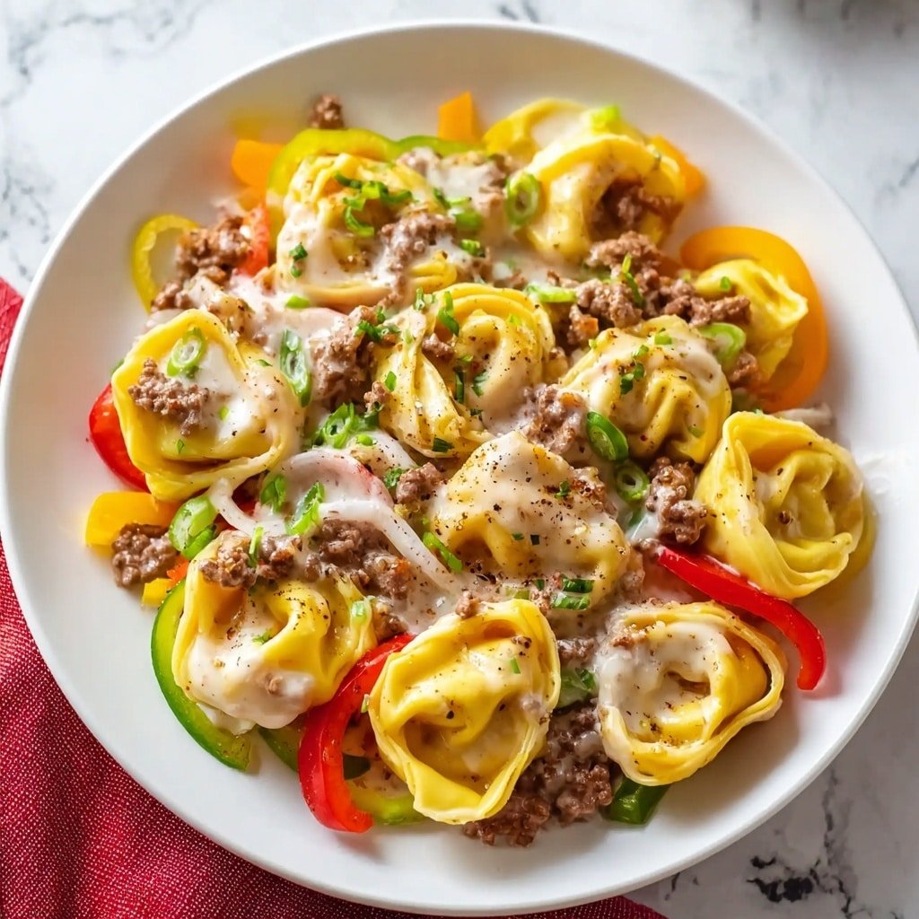 Cheesesteak Tortellini Recipe - Article Image 2 — Cheesesteak Tortellini, cheesesteak tortellini recipe, easy cheesesteak pasta, slow cooker cheesesteak dish, hearty tortellini dinner