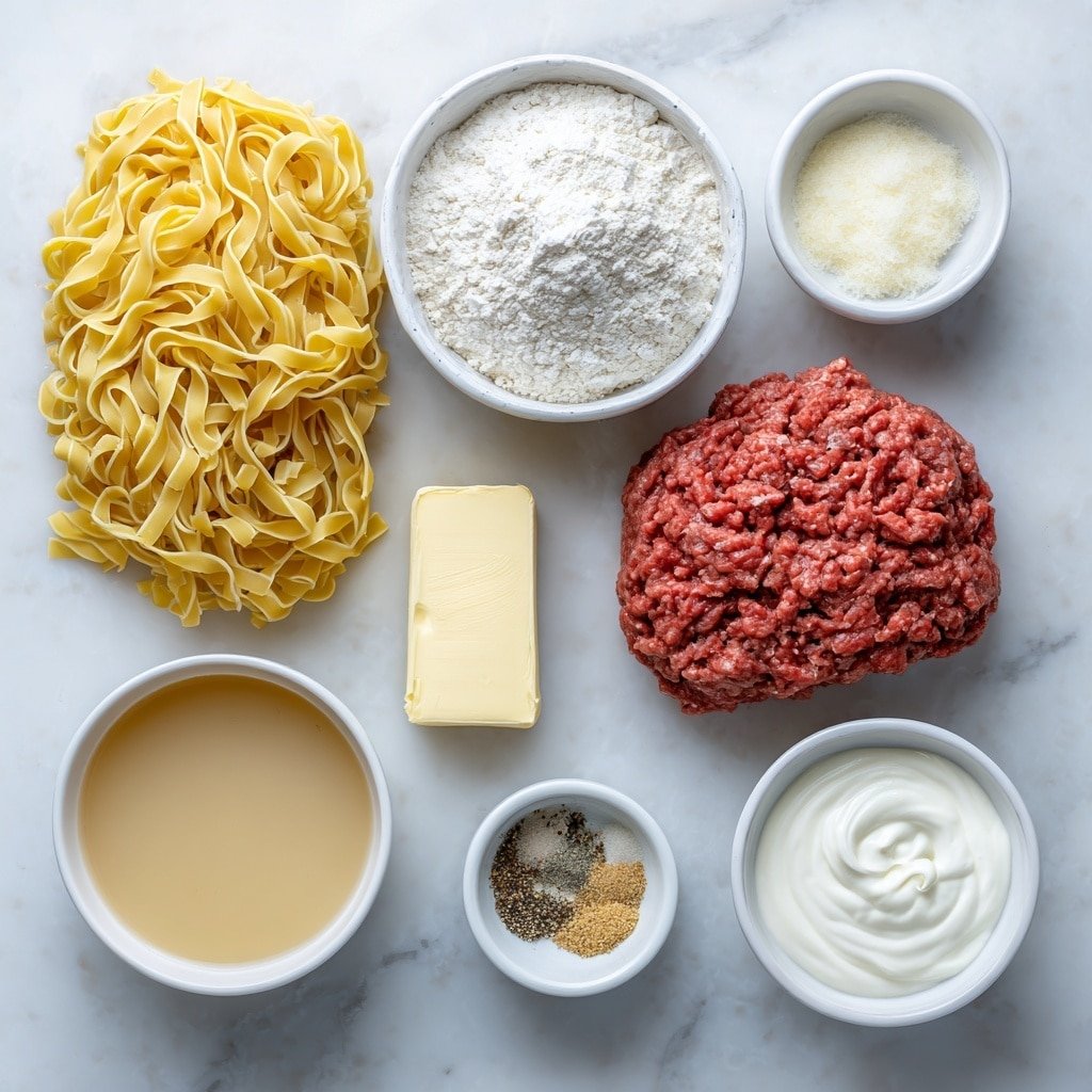 Flat lay of cooked egg noodles arranged in a small mound, a raw portion of ground beef in rich red color, a square of pale yellow butter, a small white ceramic bowl filled with white flour, a small white bowl with light brown beef broth, a small white bowl of creamy white milk, small piles of garlic powder, onion powder, black pepper, and salt each sprinkled neatly on the white surface, and a small white bowl of smooth white sour cream, all placed thoughtfully and symmetrically on a clean white marble surface, soft natural light, photo taken with an iPhone, professional food photography style, fresh ingredients, white ceramic bowls, no bottles, no duplicates, no utensils, no packaging --ar 1:1 --v 7 --p m7354639359234015250 — Ground Beef Stroganoff, creamy beef stroganoff recipe, easy beef stroganoff, comfort food dinner, quick weekday meals
